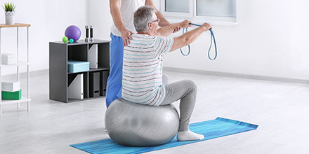 photograph of a man on an exercise ball as part of post-heart surgery cardiac rehabilitation physiotherapy