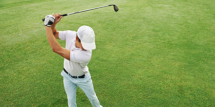 photograph of an amateur golfer swinging a golf club with perfect form following the Fit-Fore Golf program